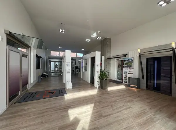 Moderner Ausstellungsraum für Türen und Fenster mit Holzfußboden und großen Glasfronten.