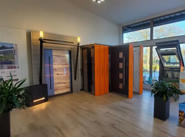 Moderne Ausstellung von Haustüren und Fenstern in einem hellen Showroom mit Holzfußboden.